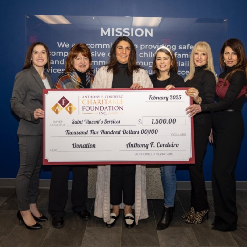 Six women pose with a large donation check for $1,500 to Saint Vincent's Services.