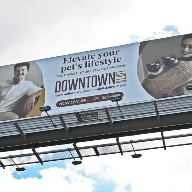 Billboard promoting pet-friendly living, featuring a man with a dog and a woman holding two cats.