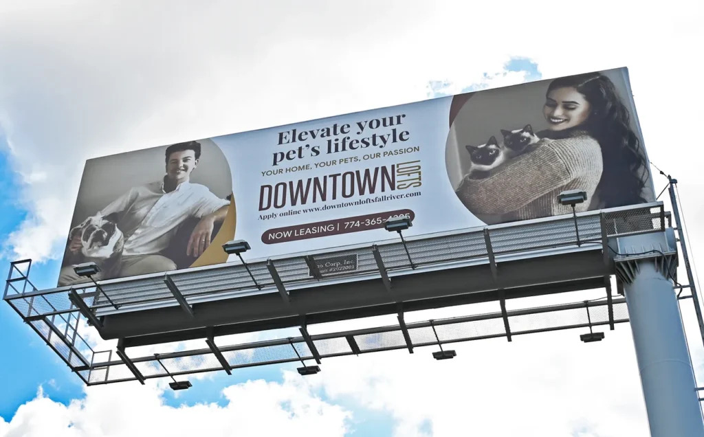 Billboard promoting pet-friendly living, featuring a man with a dog and a woman holding two cats.