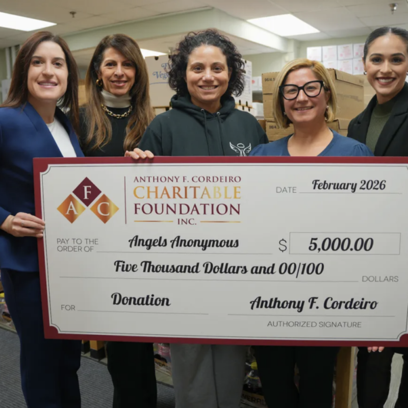 Five women hold a large check for $5,000, donating to Angels Anonymous in February 2026.