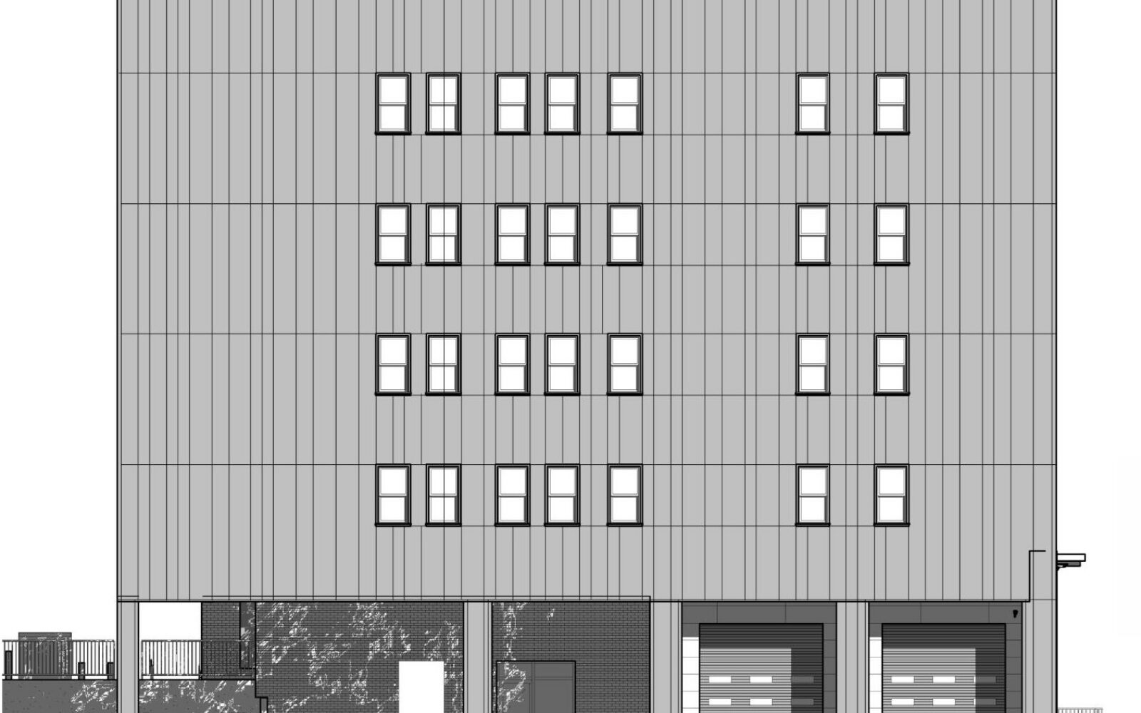 A five-story building with multiple windows and two garage doors at the base.