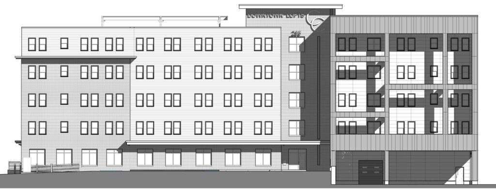 Five-story building with multiple windows and a modern design, featuring a parking area on the right.