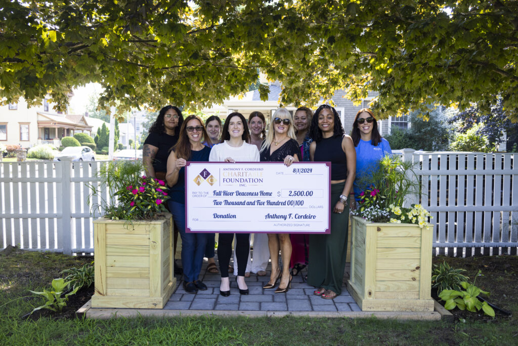 Group of people holding a large donation check for $2,500 to the Full River Deaconess Home.