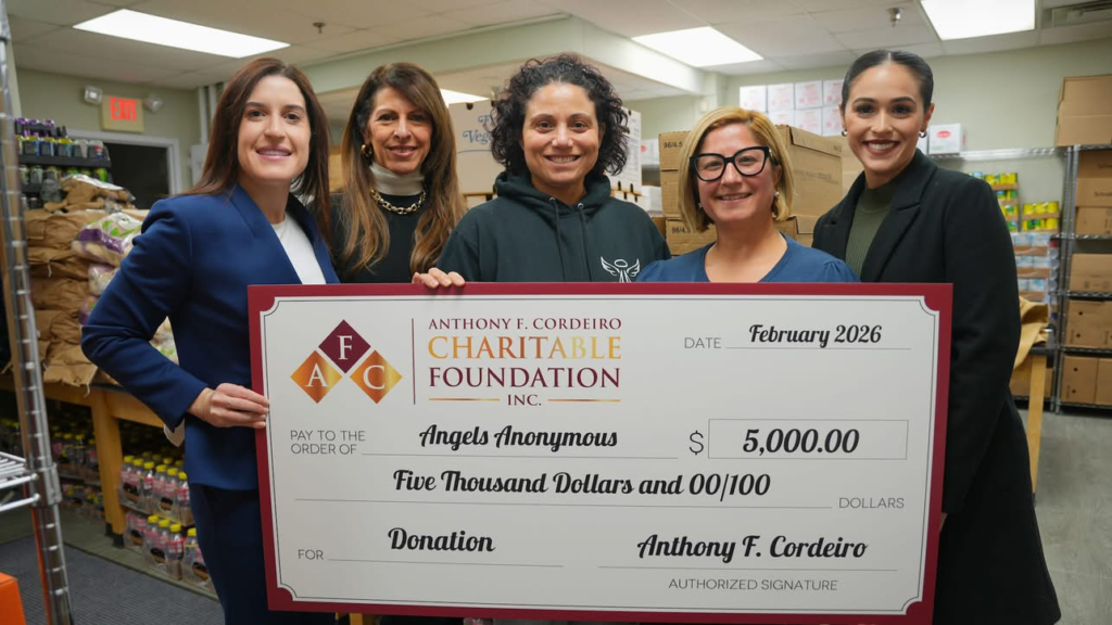 Five women hold a large check for $5,000, representing a donation to Angels Anonymous.
